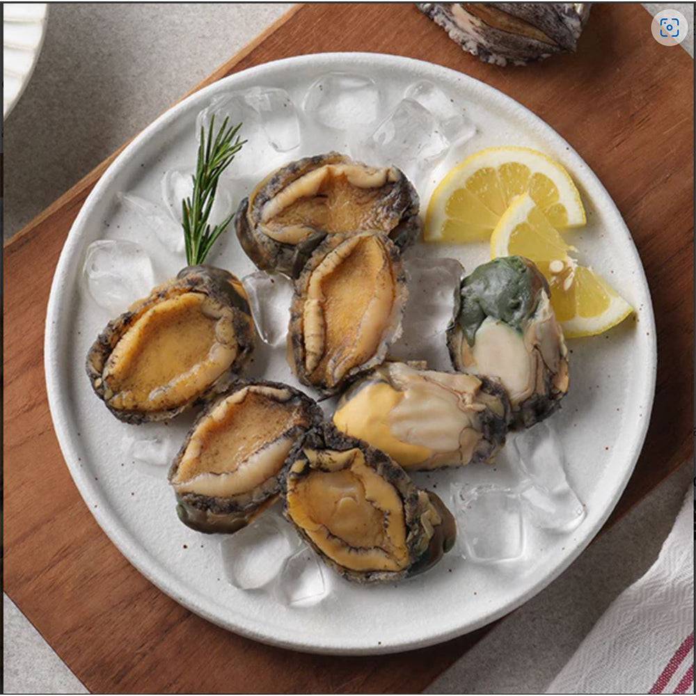 a white plate topped with oysters next to a lemon wedge